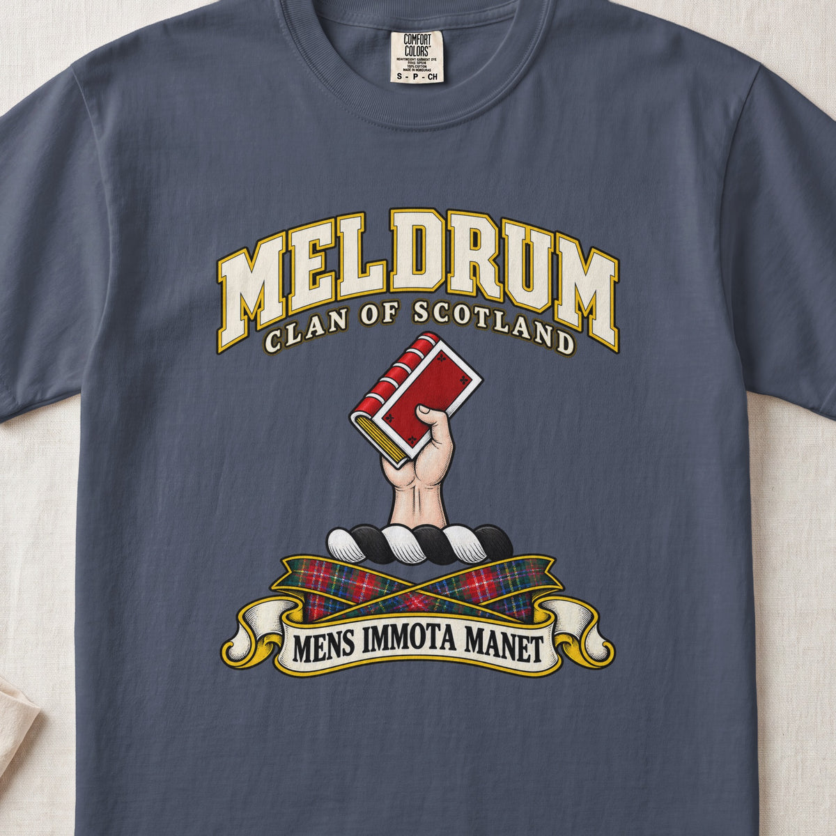 Meldrum Scottish clan T-shirt in Midnight, front view with a hand holding a red book and motto banner.