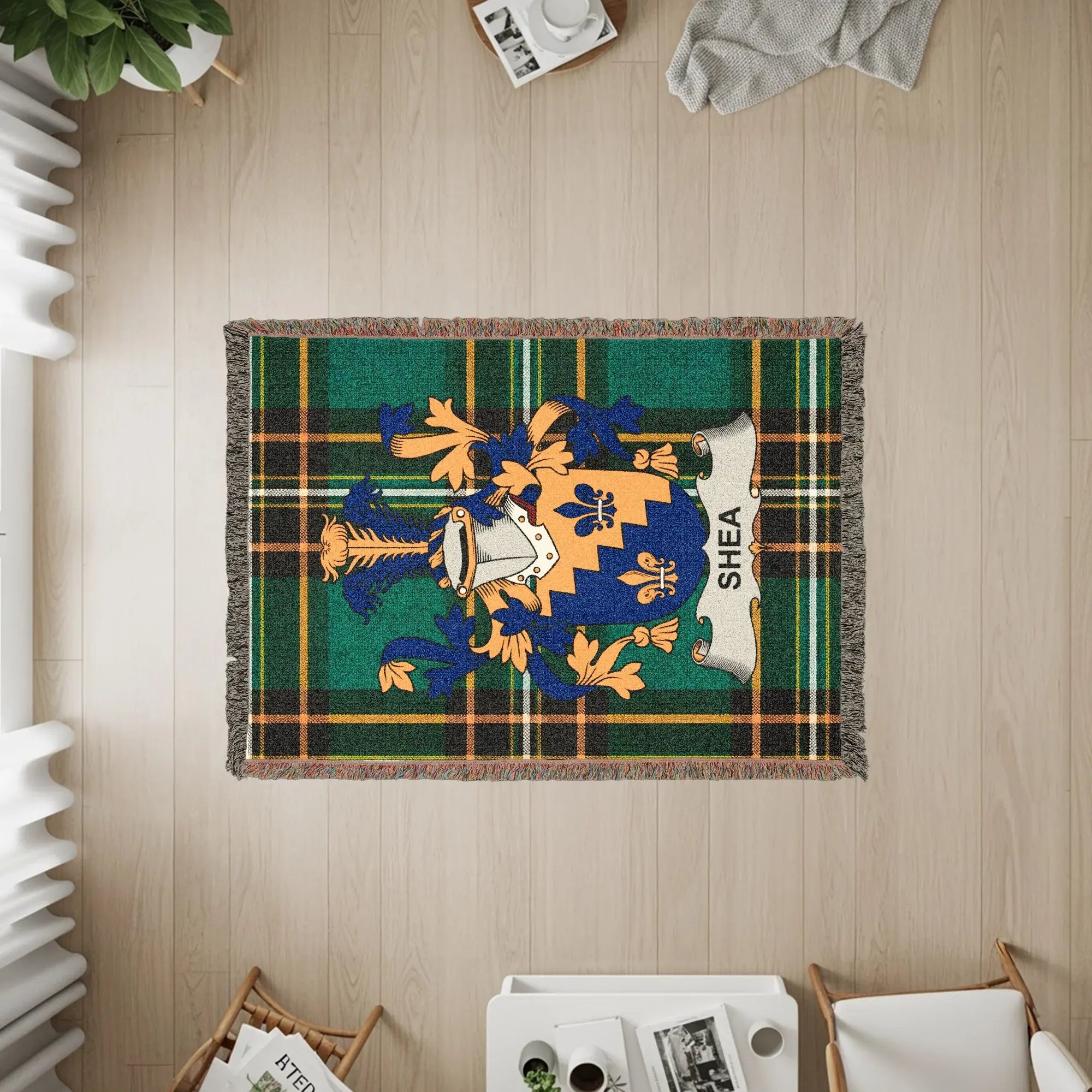 Green and blue plaid woven blanket with a crest and "Shea" text.