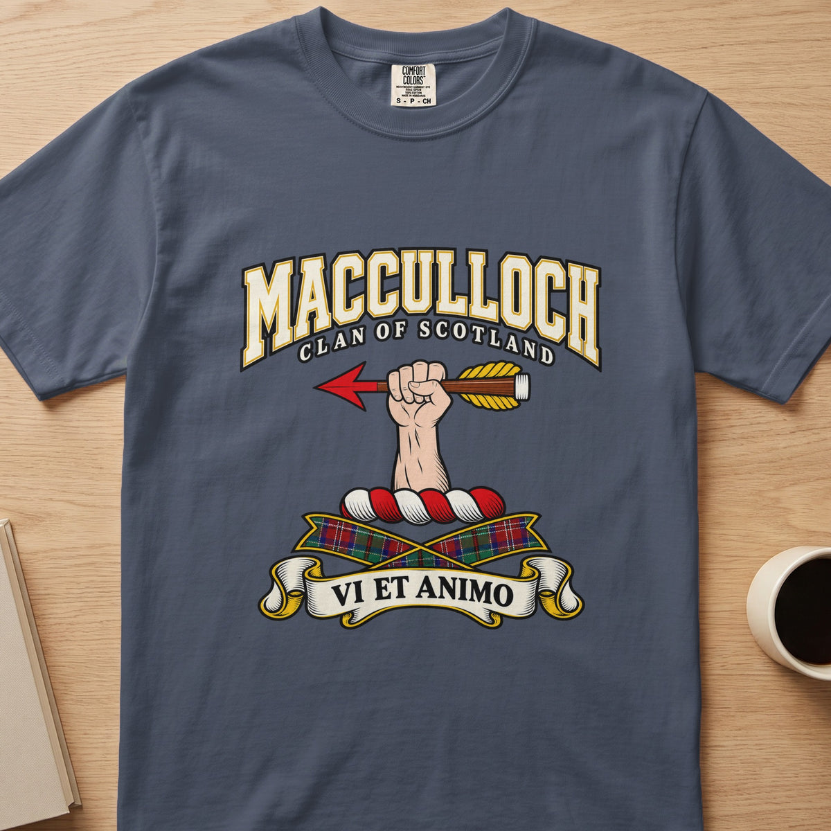 MacCulloch clan crest with hand holding an arrow on a slate blue Comfort Colors T-shirt, front view
