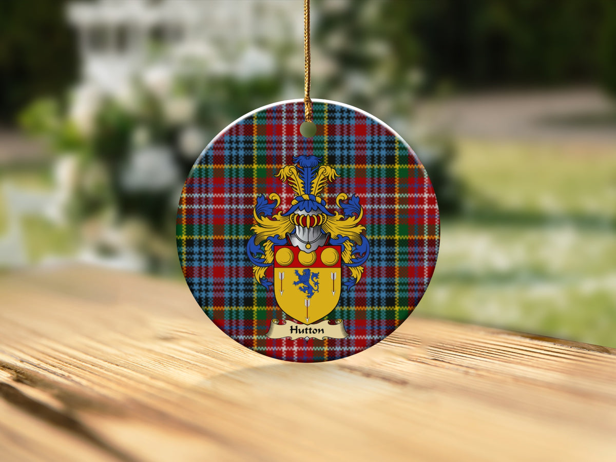 Round Hutton Scottish clan ornament with family crest on a Caledonia tartan background