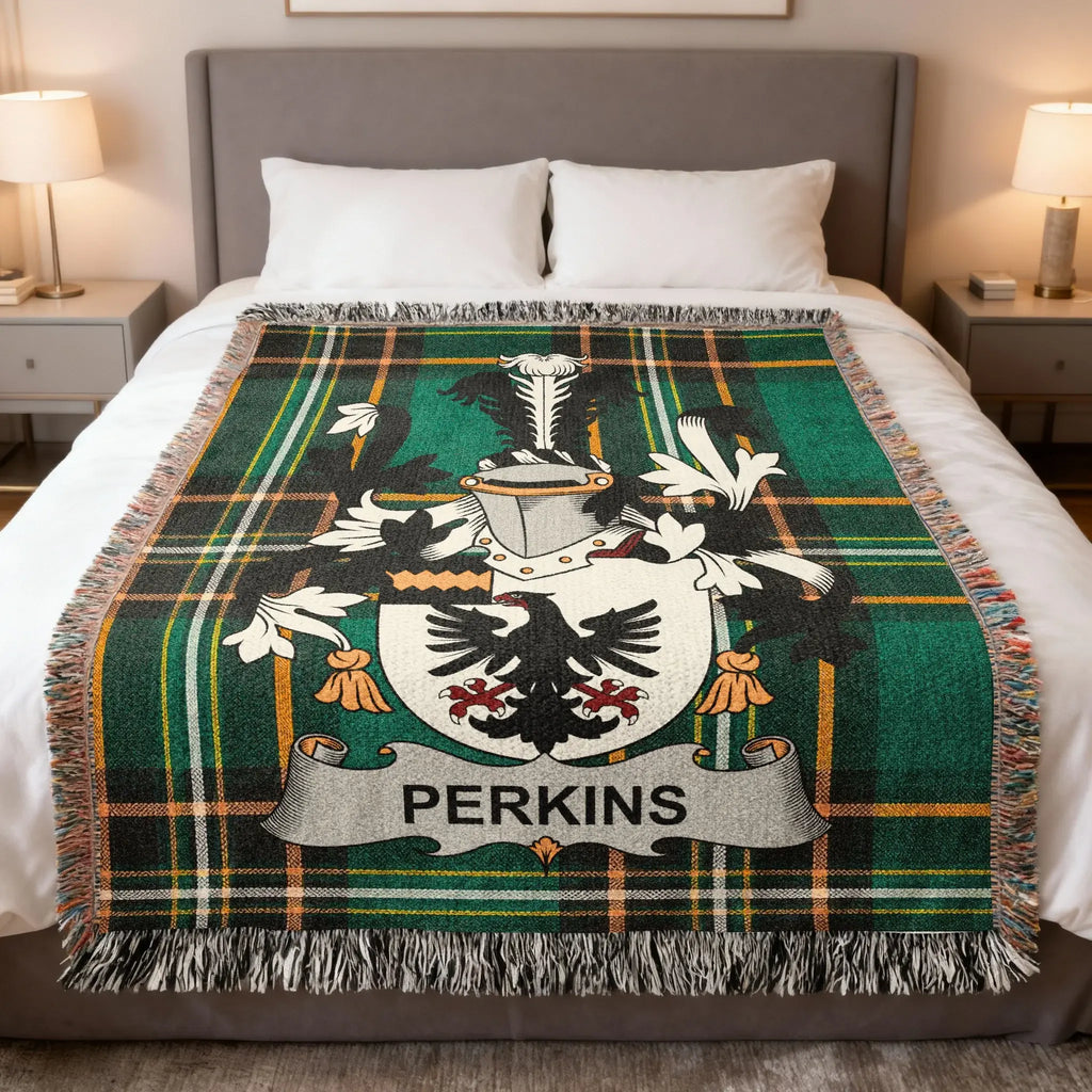 Perkins family crest on a green and black tartan blanket draped on a bed.