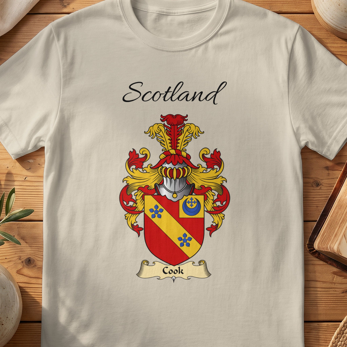 Sand Cook Scottish family shield T-shirt featuring a gold diagonal band with blue flowers on red