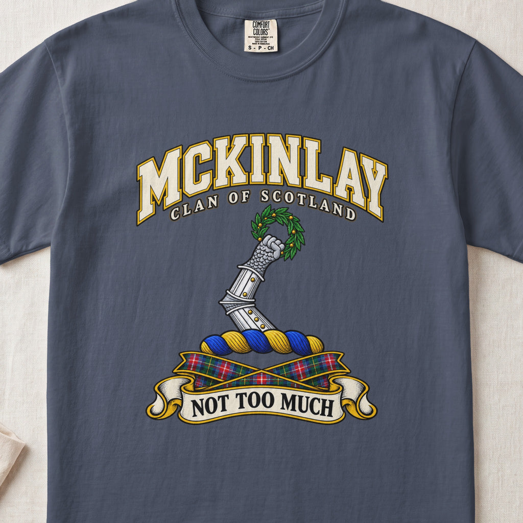 McKinlay Scottish clan T-shirt in Midnight, front view with an armored arm holding a green leafy wreath and motto banner.