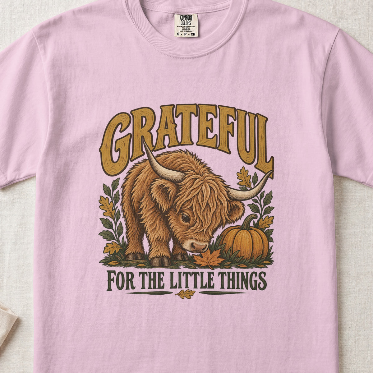 Grateful for the Little Things Highland cow design on a Blossom Comfort Colors 1717 T-shirt, flat lay
