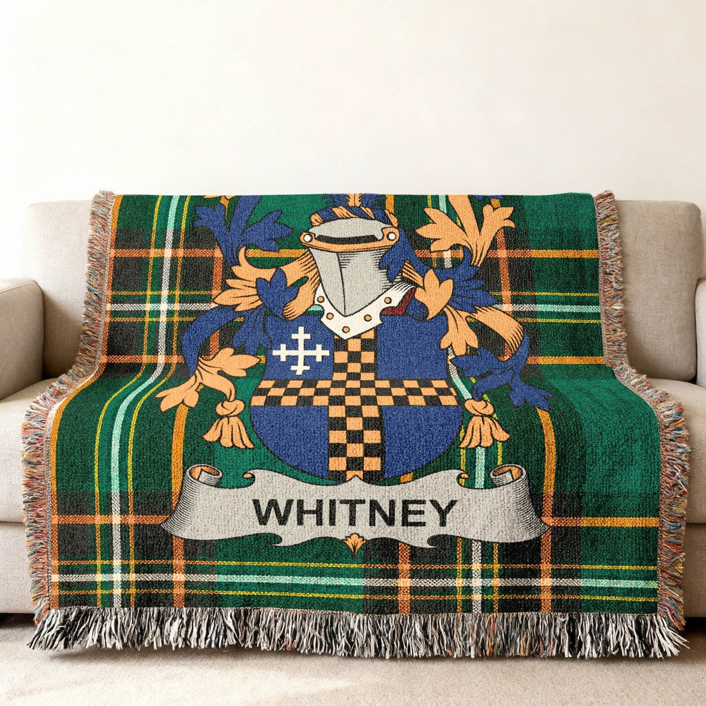 Plaid throw blanket with Whitney family crest in blue, gold, and green.