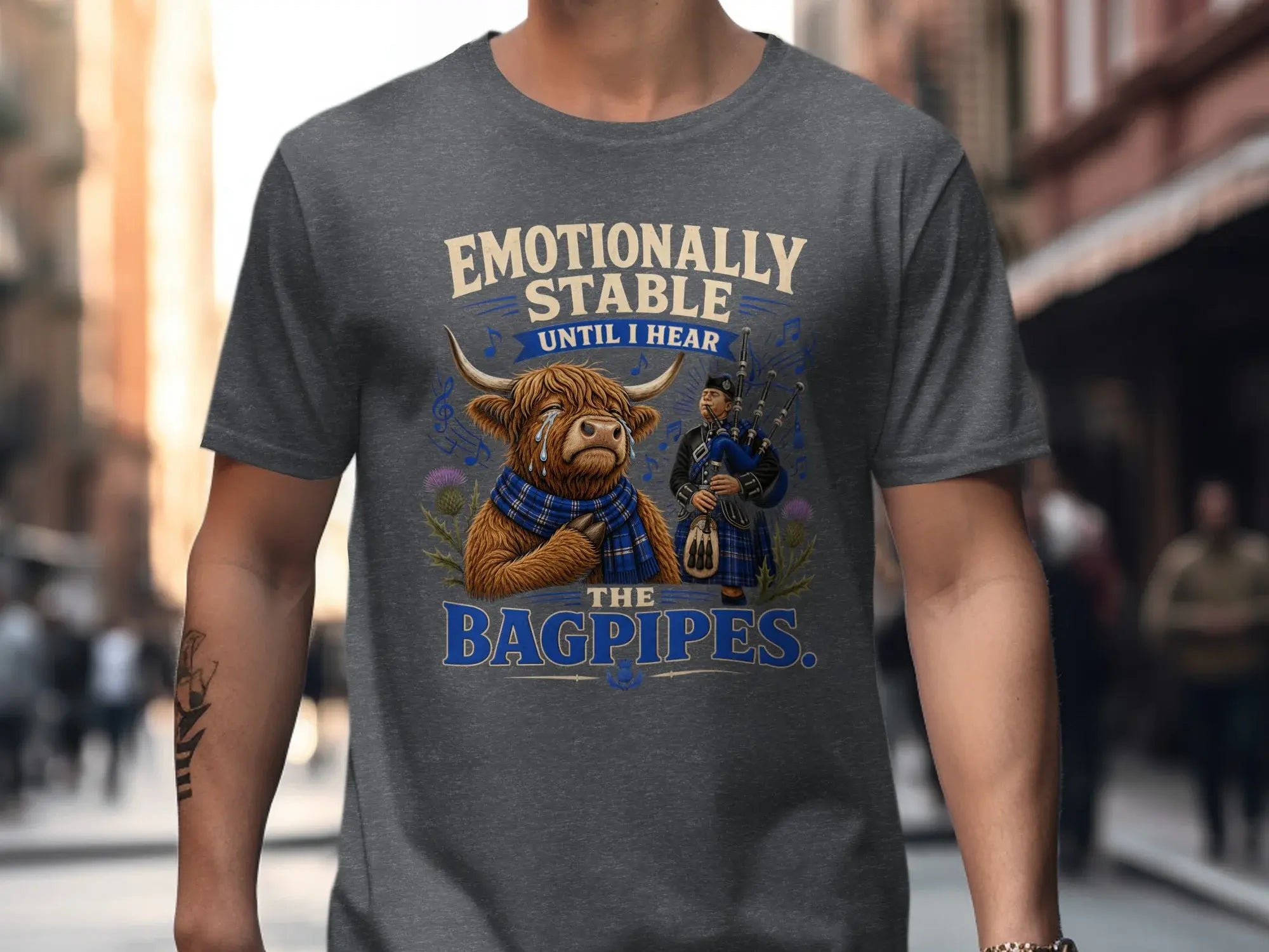 Highland cow wearing a scarf with bagpipes and text "Emotionally stable until I hear the bagpipes."