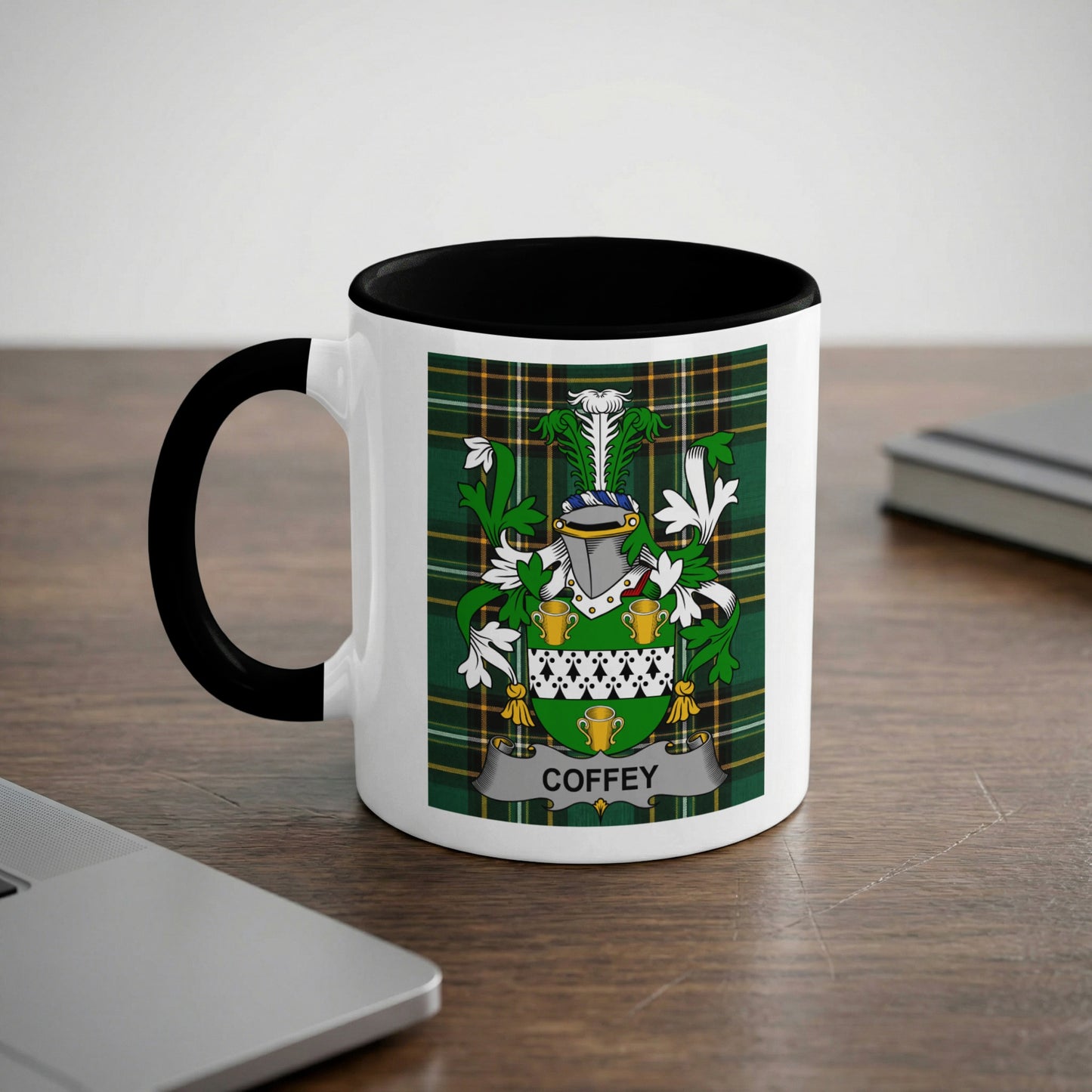 White mug with black rim and handle featuring a green plaid crest with the name "Coffey".