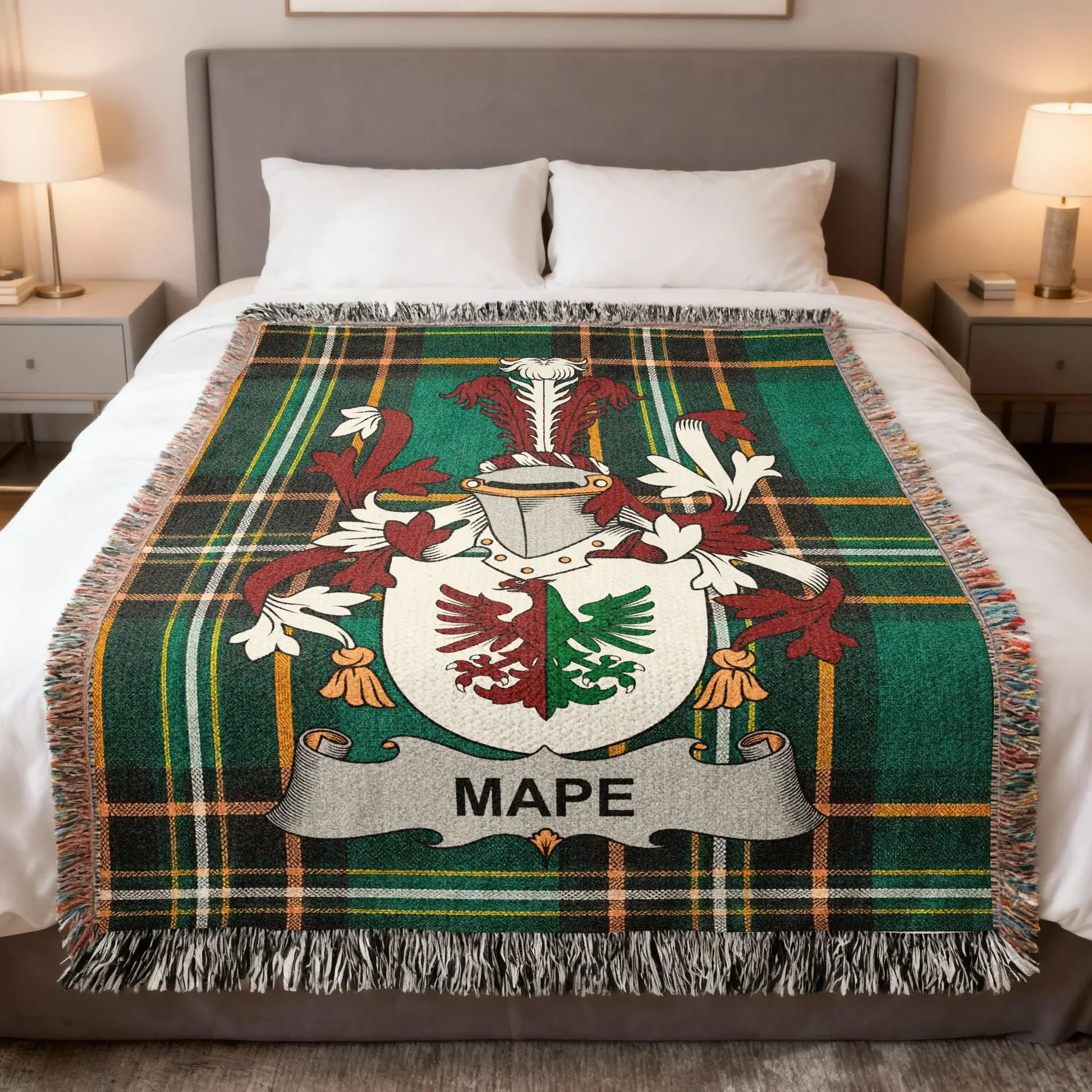 Tartan blanket with coat of arms and MAPPE crest on a bed.
