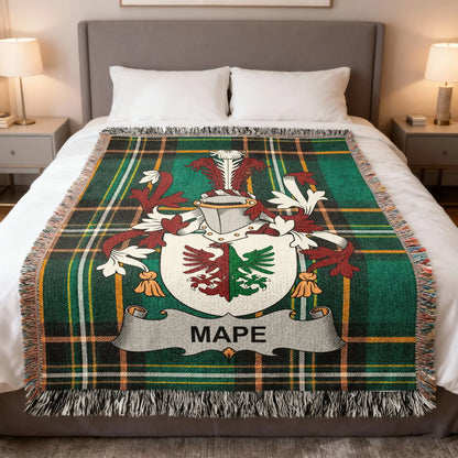 Tartan blanket with coat of arms and MAPPE crest on a bed.