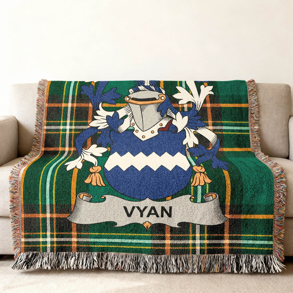 Woven blanket with Vyan family crest on a green tartan background.