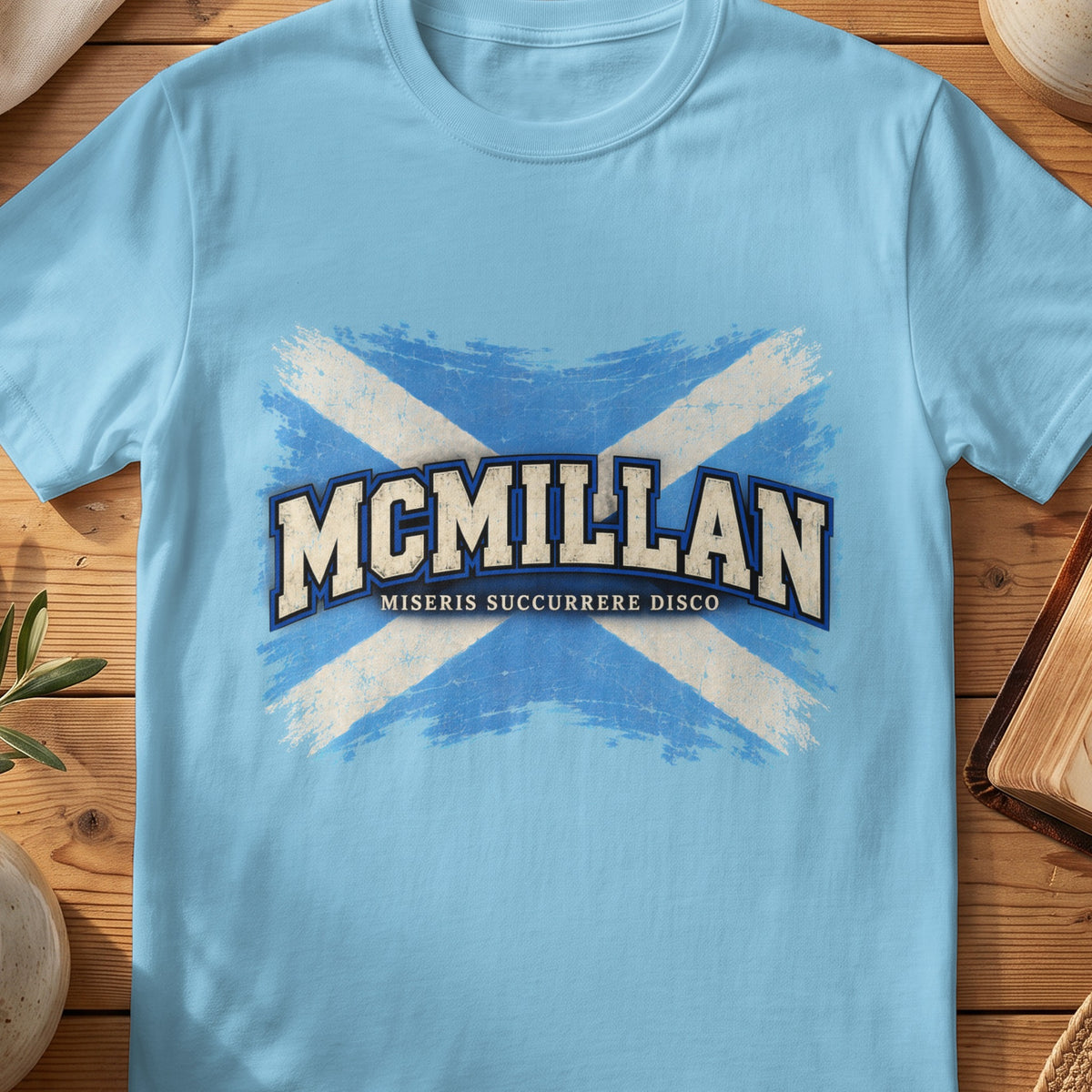 McMillan Scottish Saltire T-shirt in Sky, with distressed blue and cream flag and “Miseris Succurrere Disco” lettering.