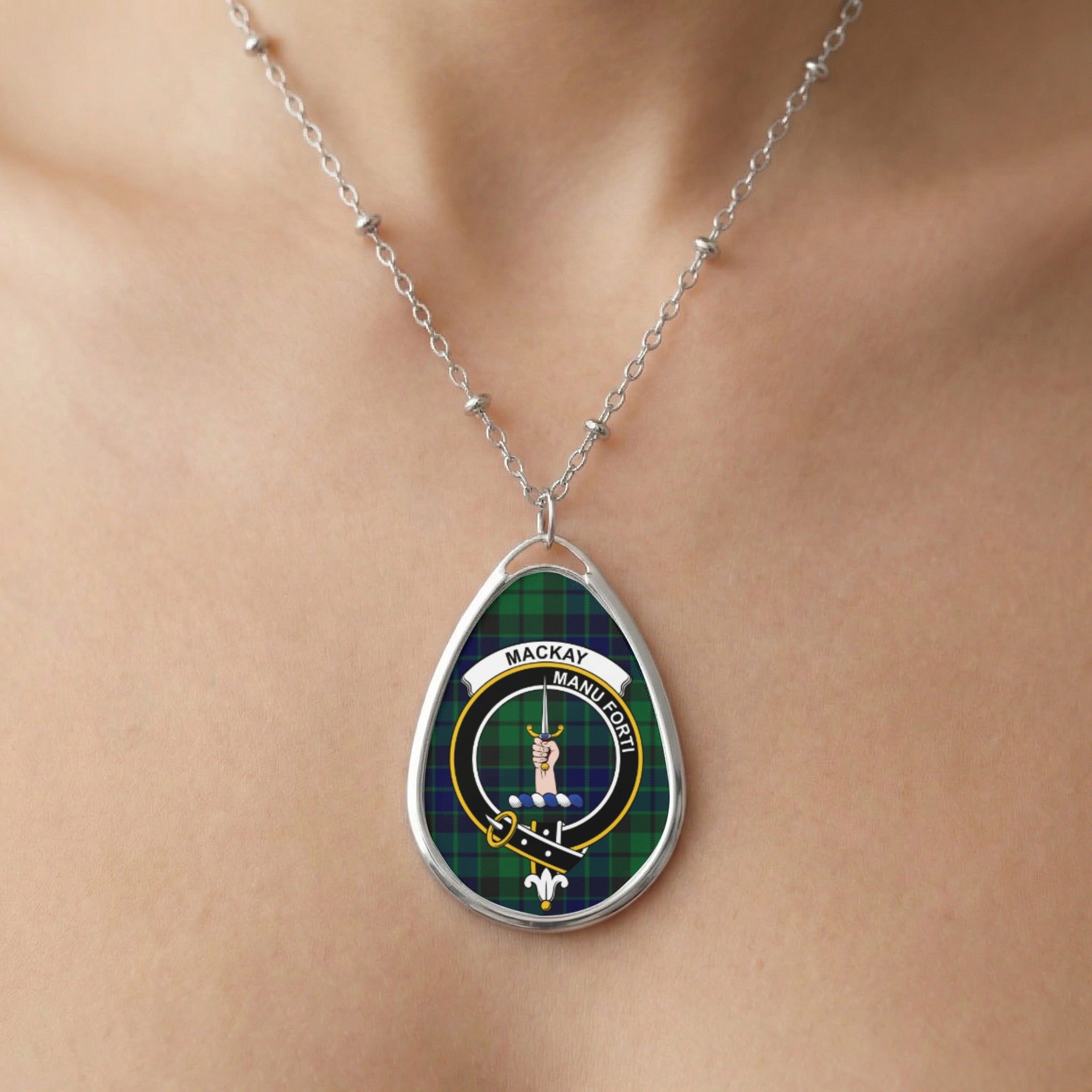 Oval pendant necklace featuring the Mackay tartan and crest with motto "Manu Forti".