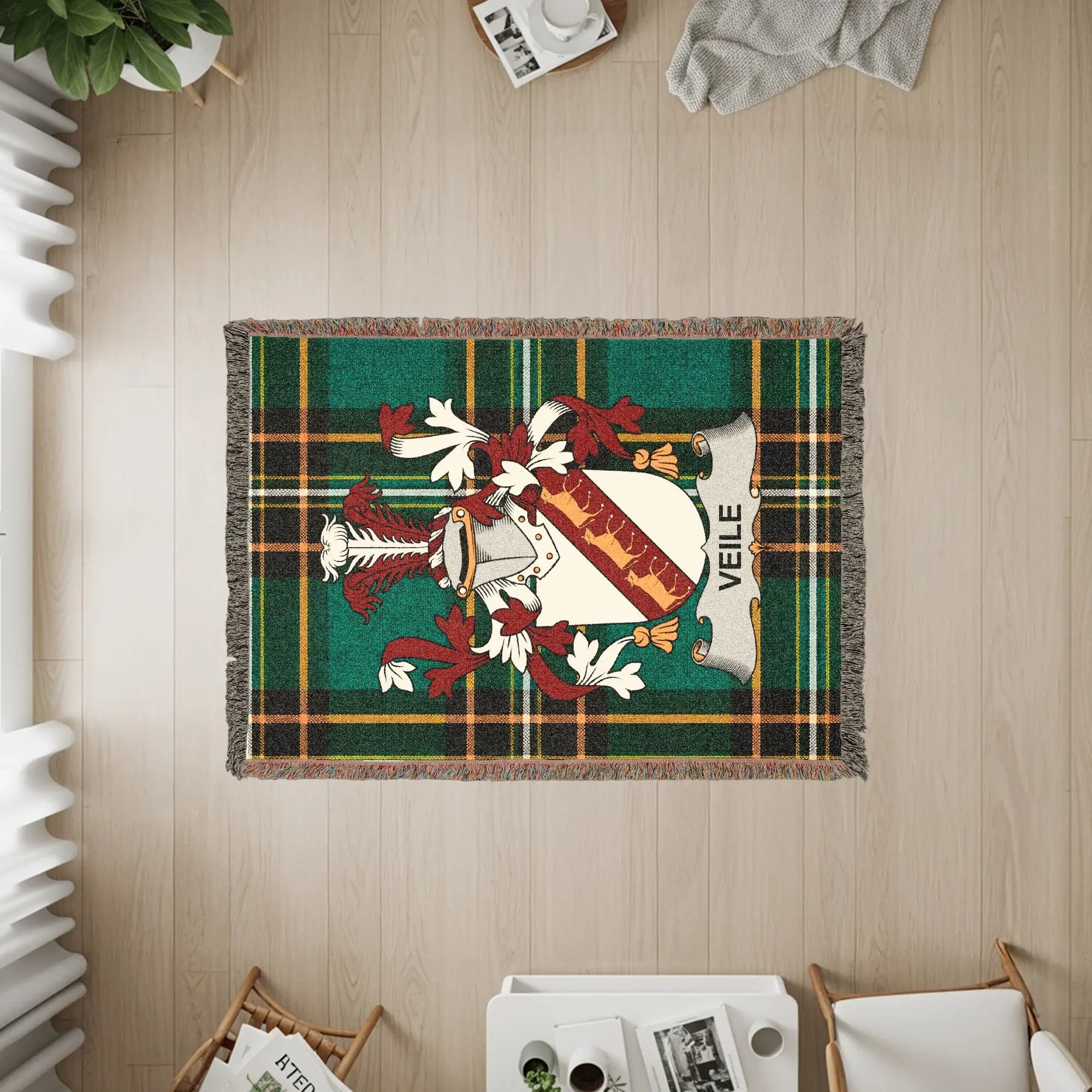 Veile family crest woven throw blanket on a wooden floor.