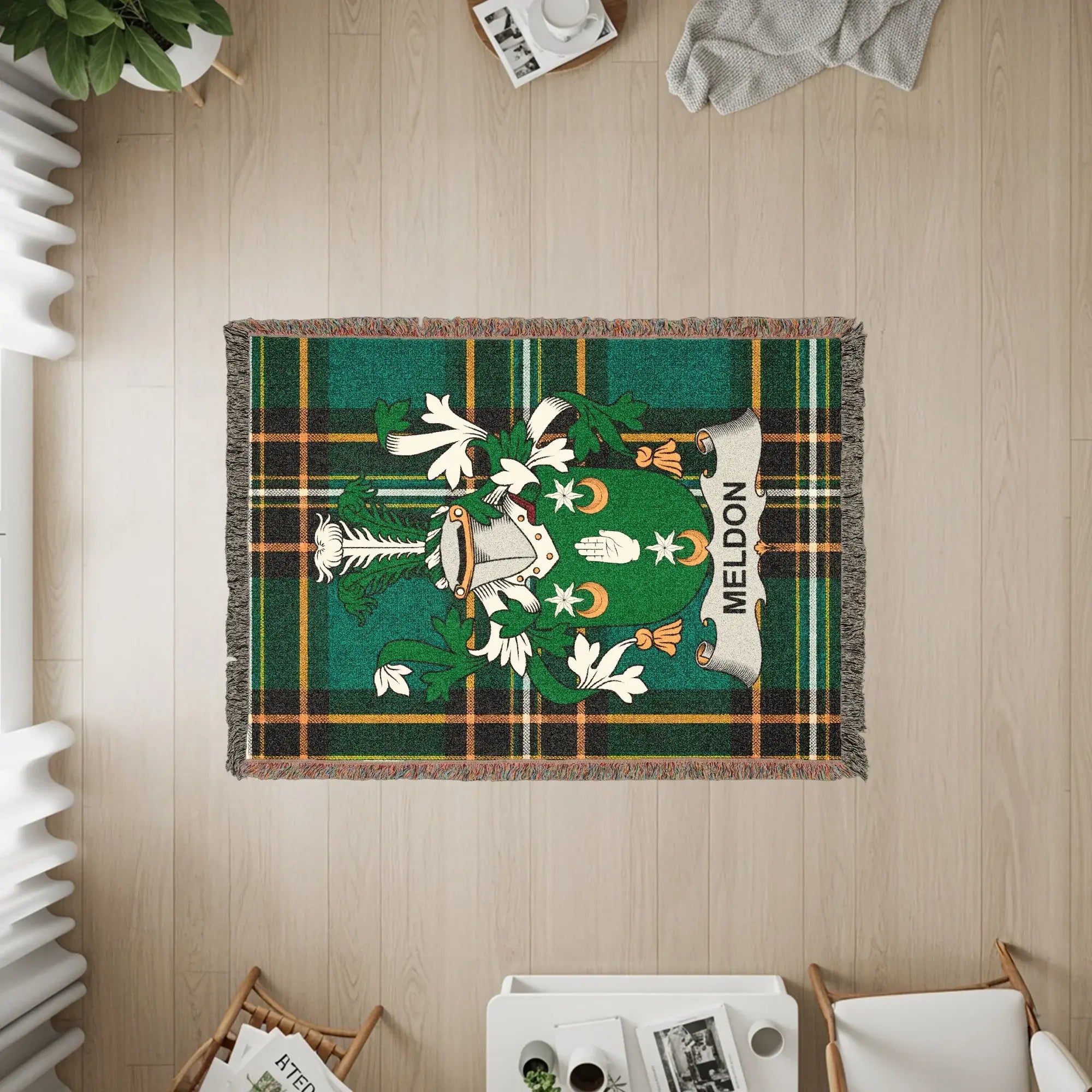 Green tartan blanket with a coat of arms featuring a shield and helmet, labeled "Meldon".