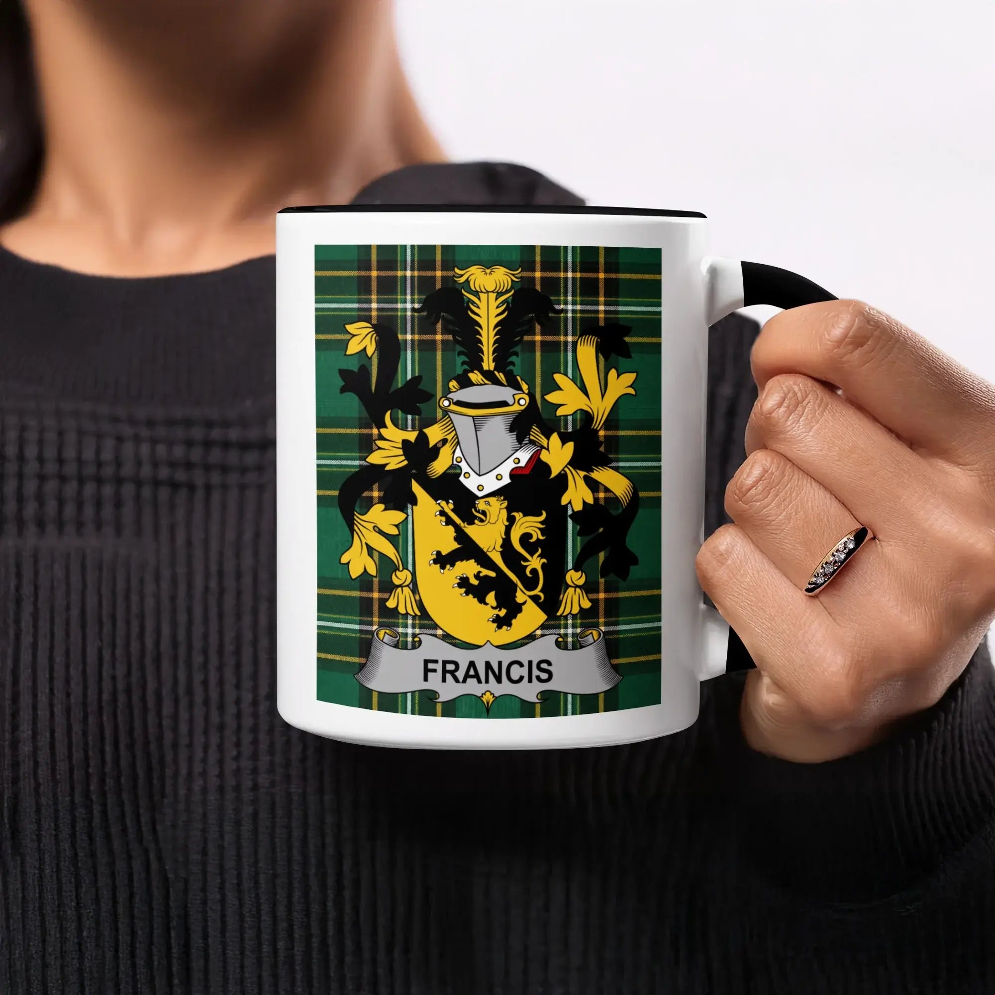 Black mug with Francis coat of arms on plaid background.