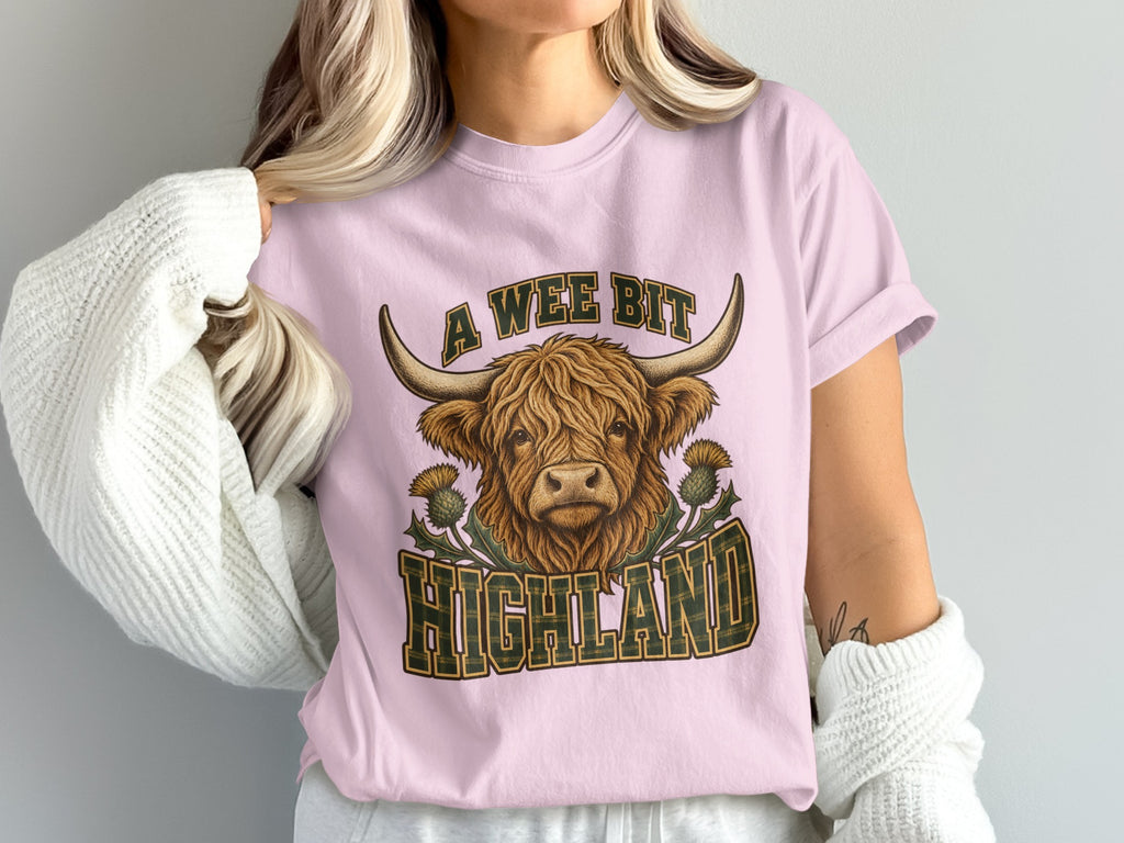 Model wearing the A Wee Bit Highland Highland cow Comfort Colors T-shirt in Blossom