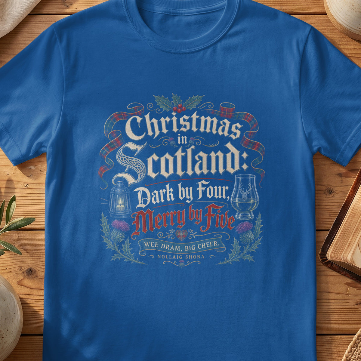 Royal blue t-shirt with "Christmas in Scotland: Dark by Four, Merry by Five" design.