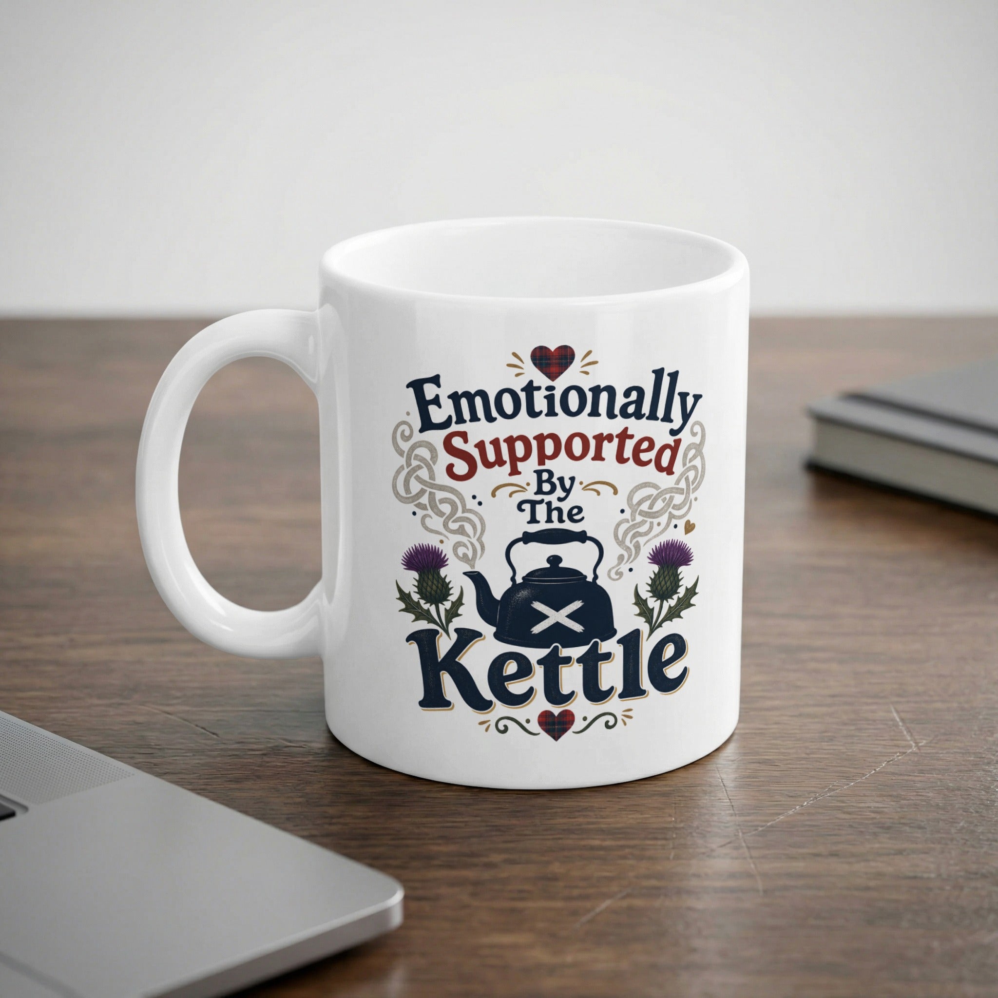 White mug with "Emotionally Supported By The Kettle" text and thistle design.