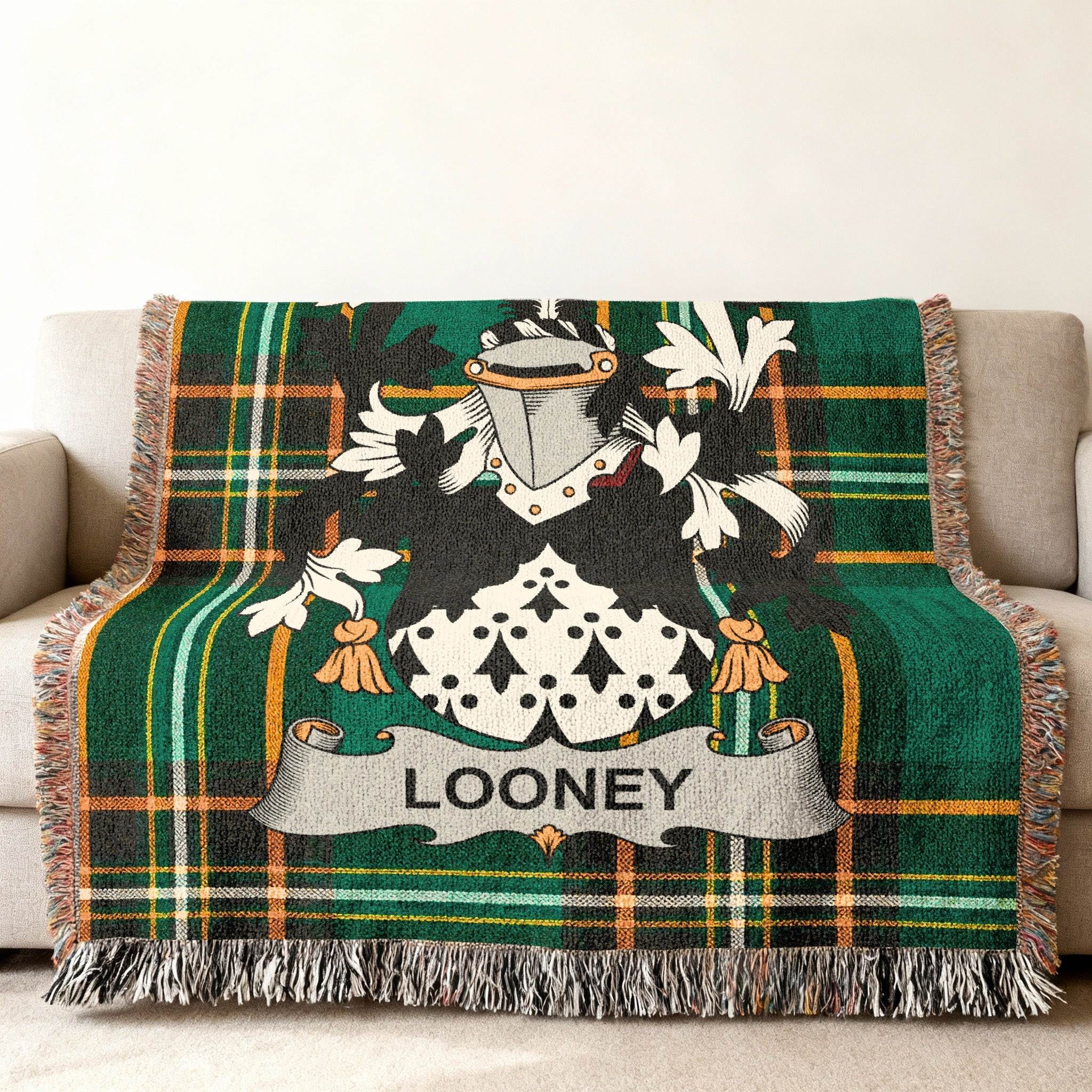 Green plaid throw blanket featuring a coat of arms with the name "LOONEY."