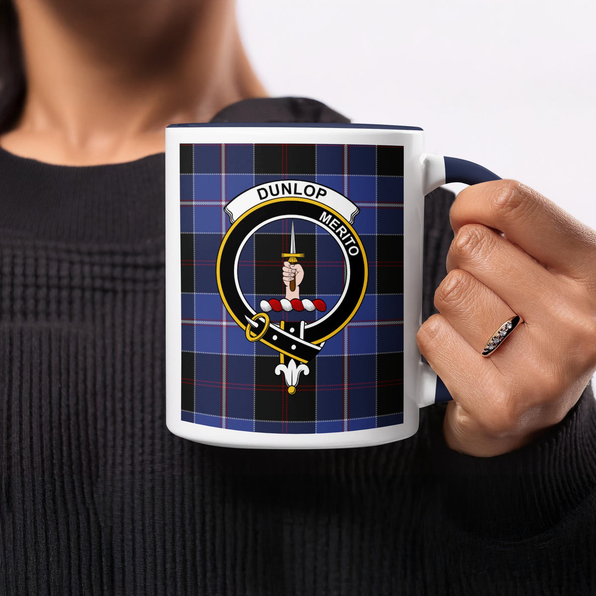 Close-up lifestyle view of Dunlop Scottish family crest artwork on a navy 11 oz accent mug with a tartan background