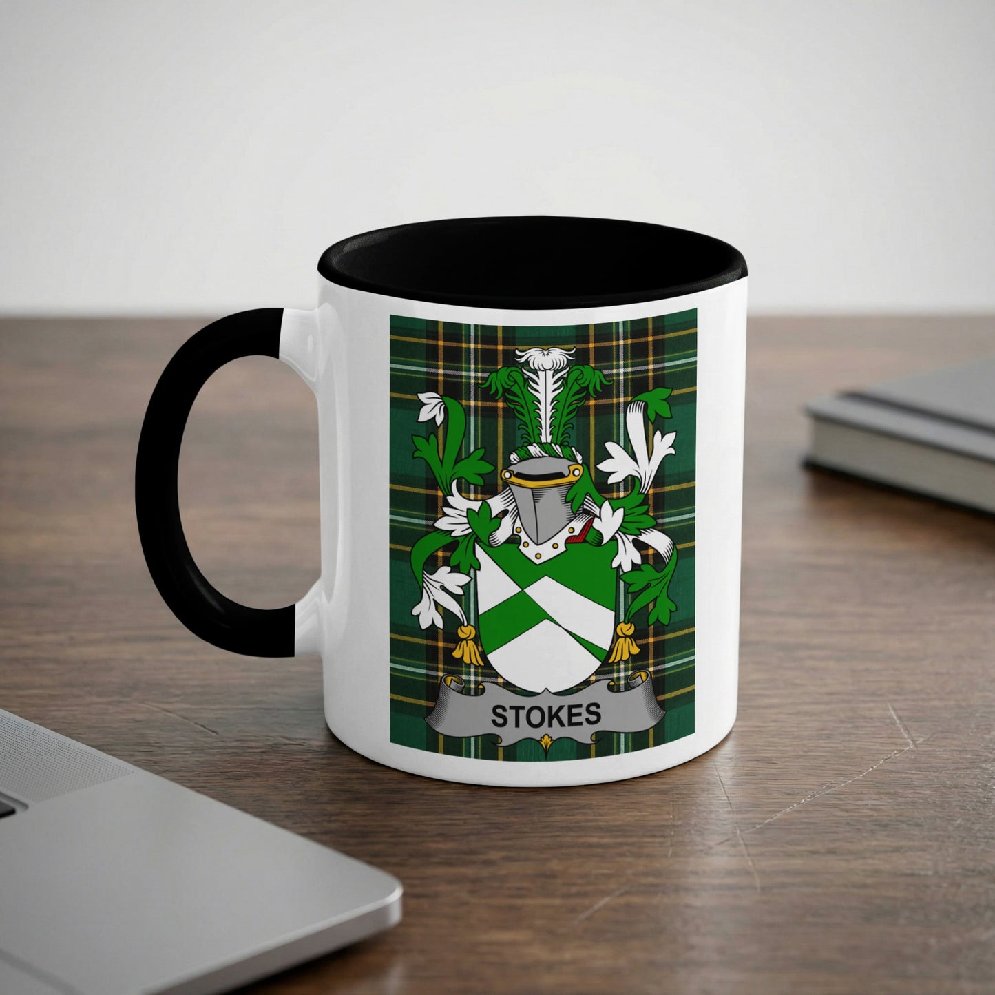 White mug with black rim, featuring the Stokes family crest on a green plaid background.