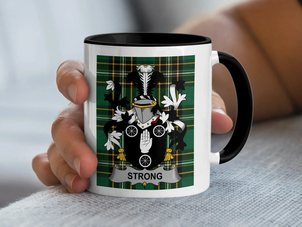 Mug with Strong family crest on green plaid background.