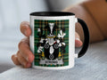 Mug with Strong family crest on green plaid background.