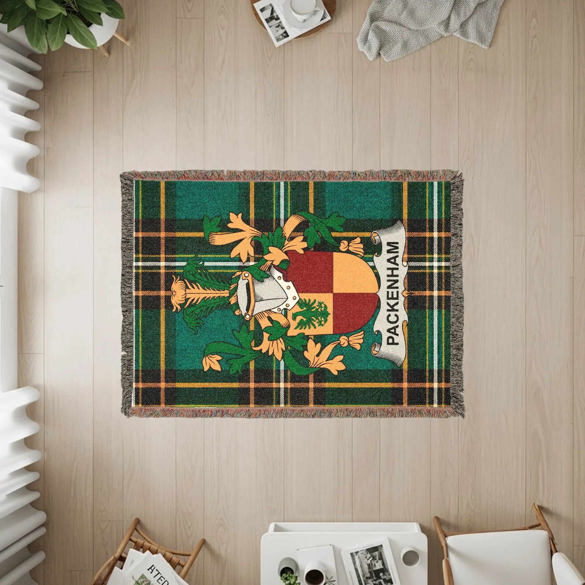 Woven tapestry blanket with Packenham family crest on green and black plaid.