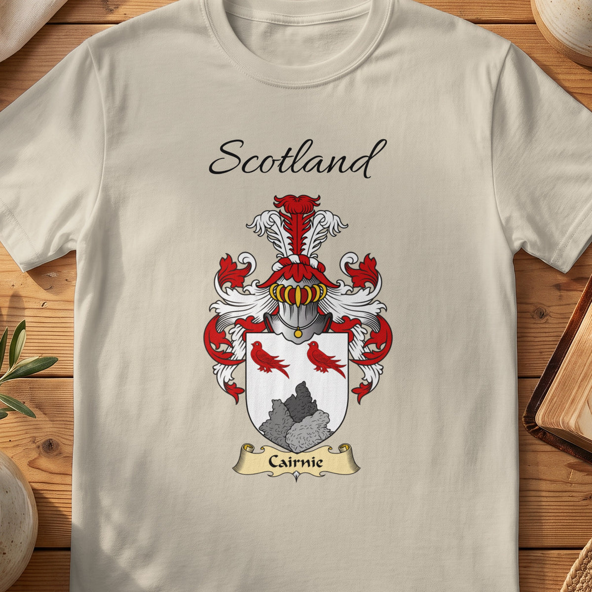 Sand Cairnie Scottish family shield T-shirt featuring red birds above a grey rocky motif