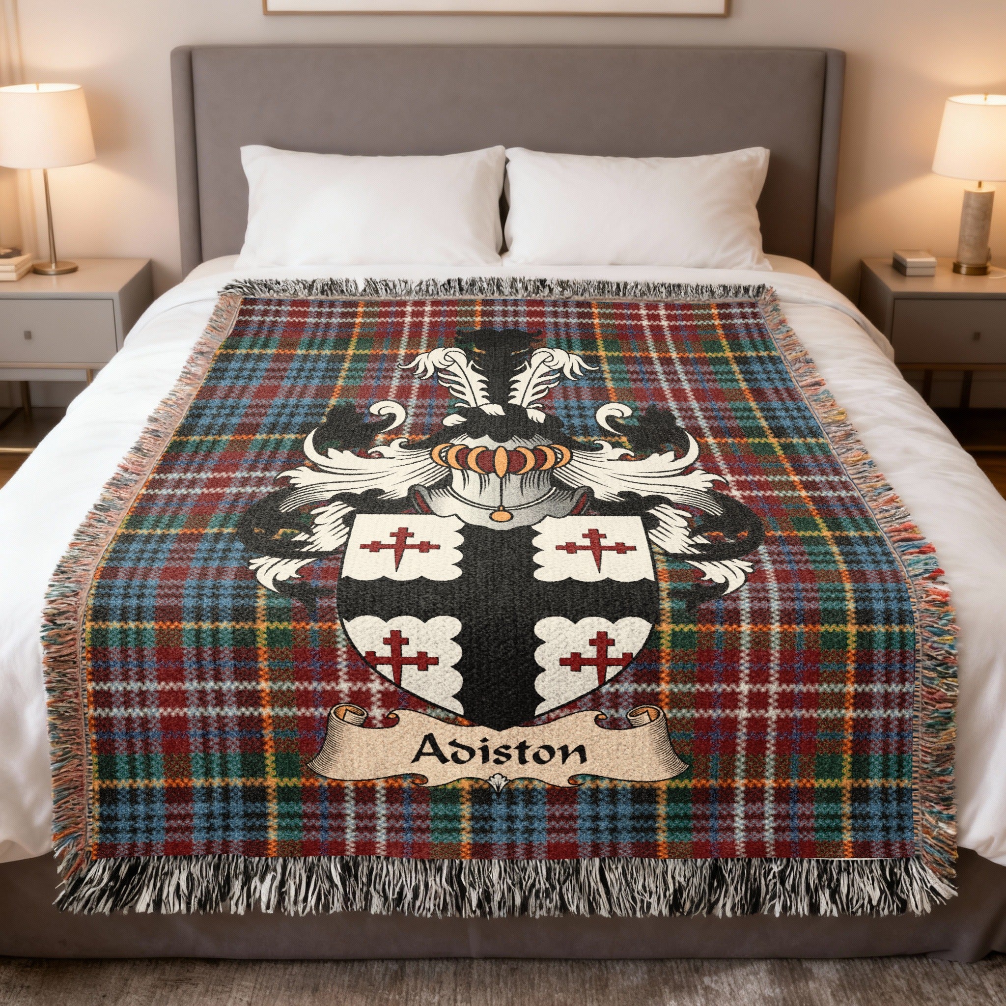 Adiston Scottish family crest woven blanket on a Caledonia tartan background, displayed on a bed