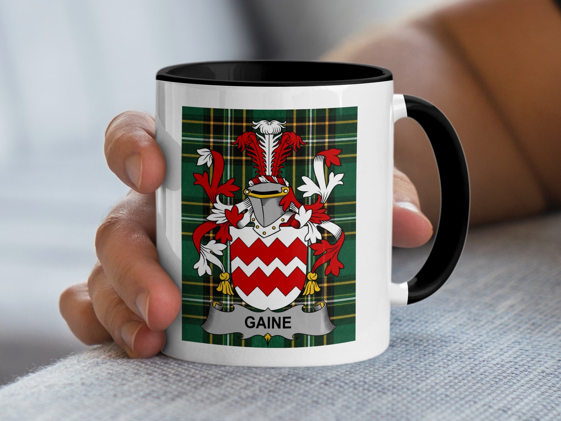 White mug with black rim displaying a red and white coat of arms with "GAINE" text.