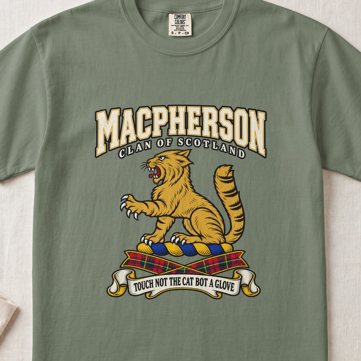 MacPherson graphic T-shirt in Moss green, front flat lay showing varsity lettering and seated gold wildcat with black stripes, raised paw and upright tail.