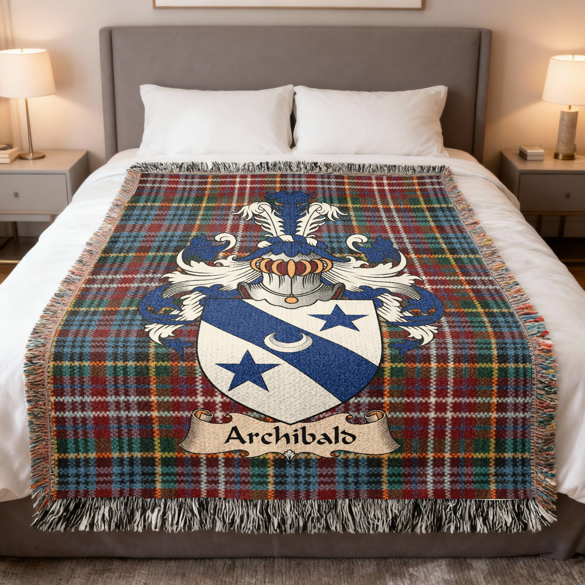Archibald Scottish family crest woven blanket on a Caledonia tartan background, displayed on a bed