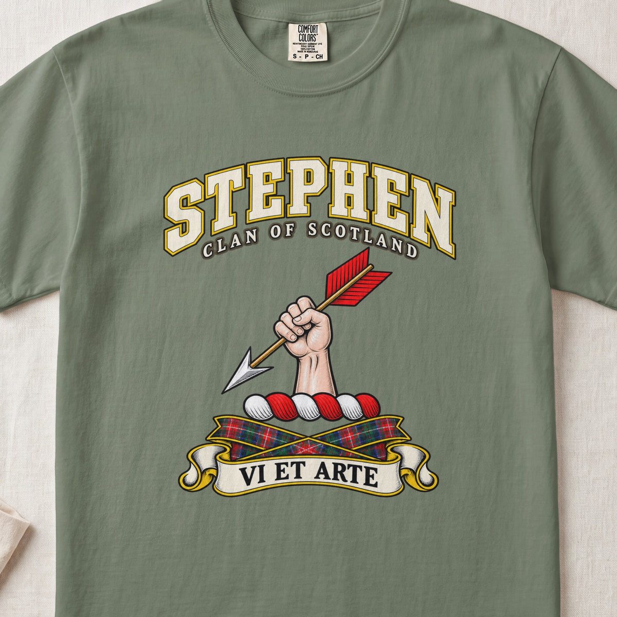 Stephen Scottish clan T-shirt in Moss, front view with a hand holding an arrow with red feathers and motto design.
