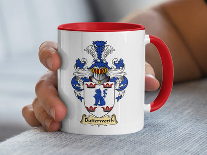 White mug with red handle, featuring a blue and gold Butterworth family crest.