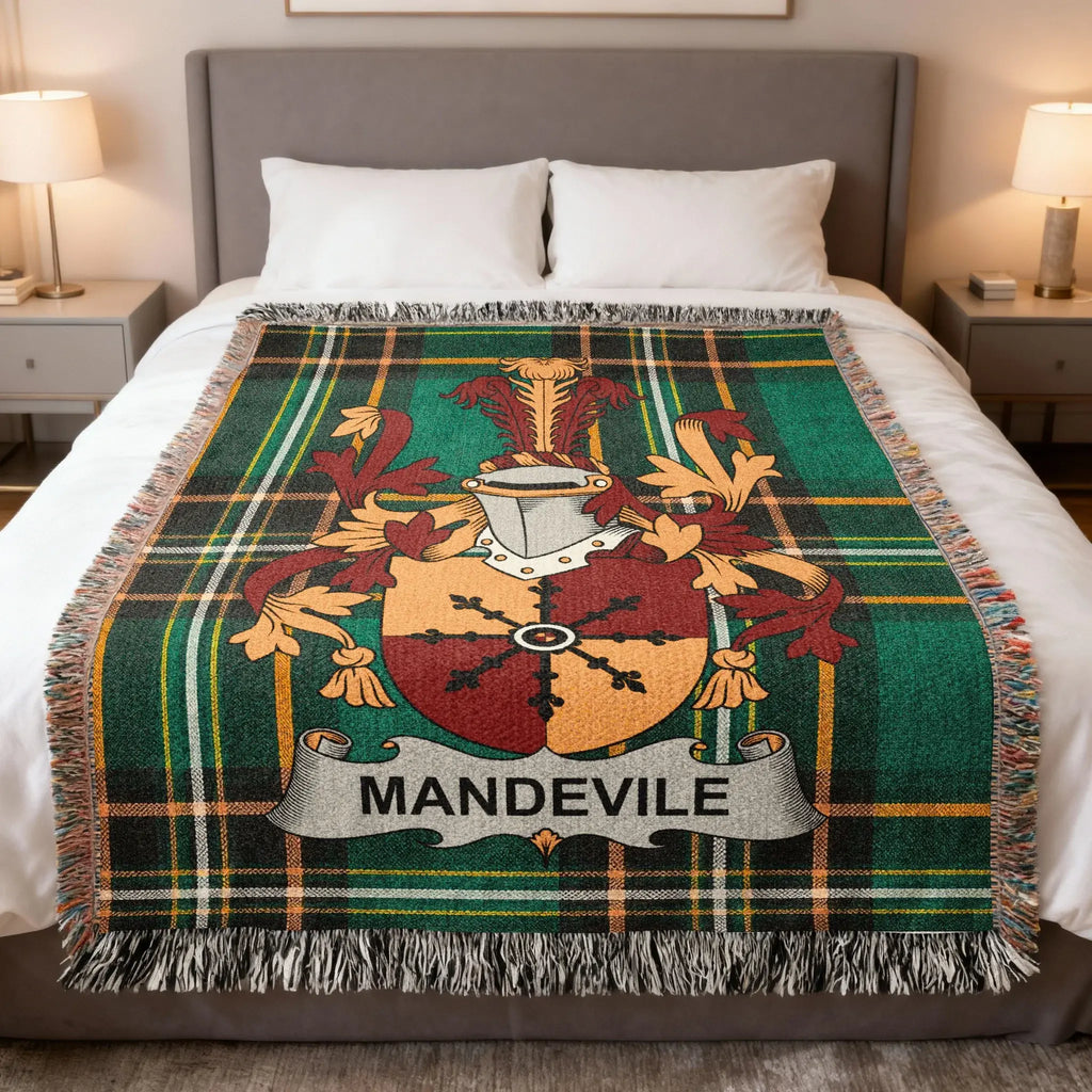 MANDVILE tartan throw blanket with coat of arms and fringed edges on a bed.