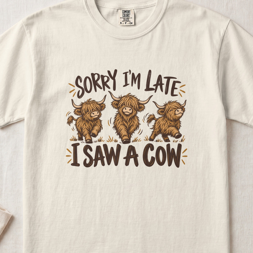 Sorry I'm Late, I Saw a Cow Highland cow design on an Ivory Comfort Colors 1717 T-shirt, flat lay