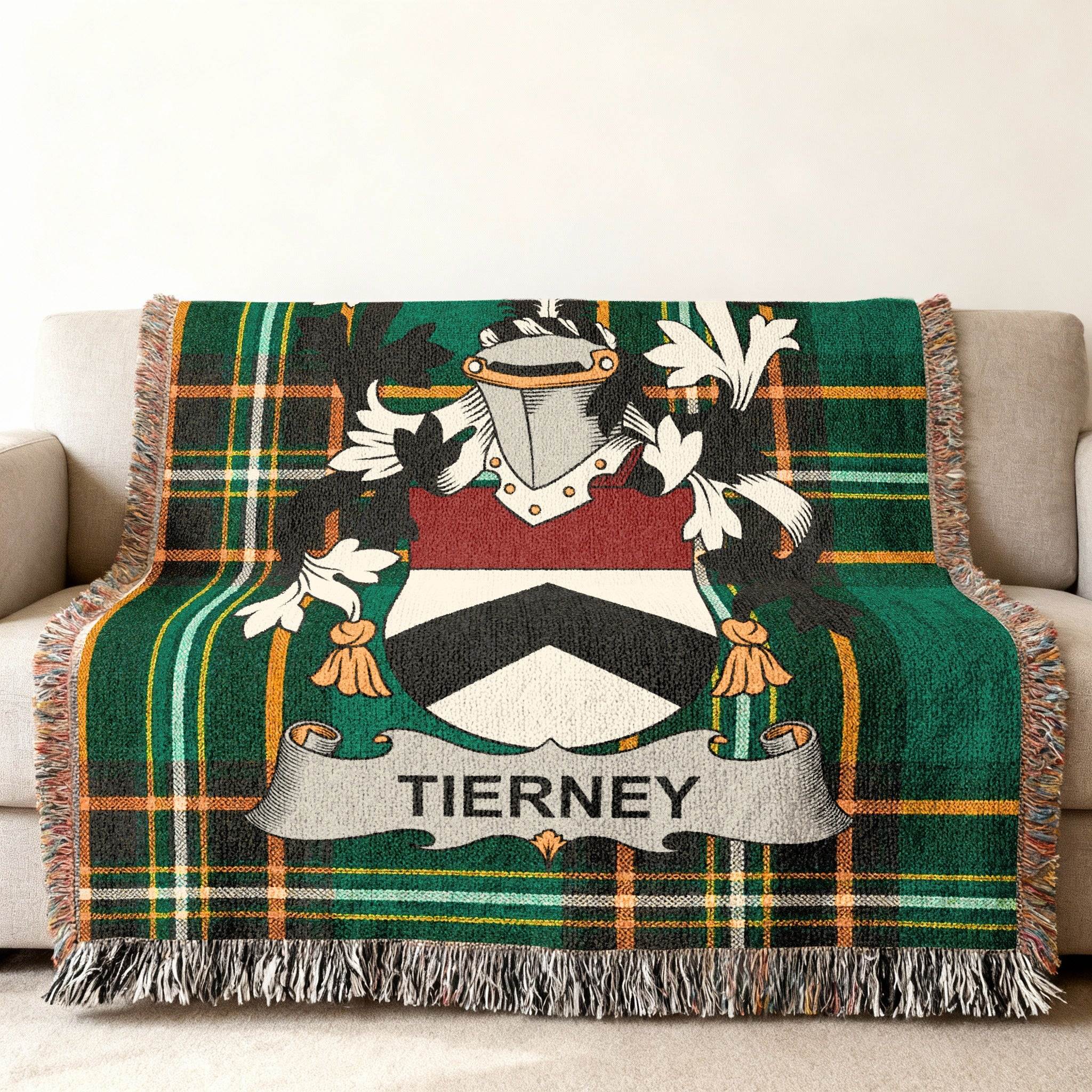 Tierney tartan blanket with crest draped over a sofa.