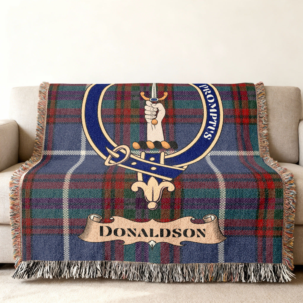 Donaldson clan tartan blanket with crest and motto draped over a sofa