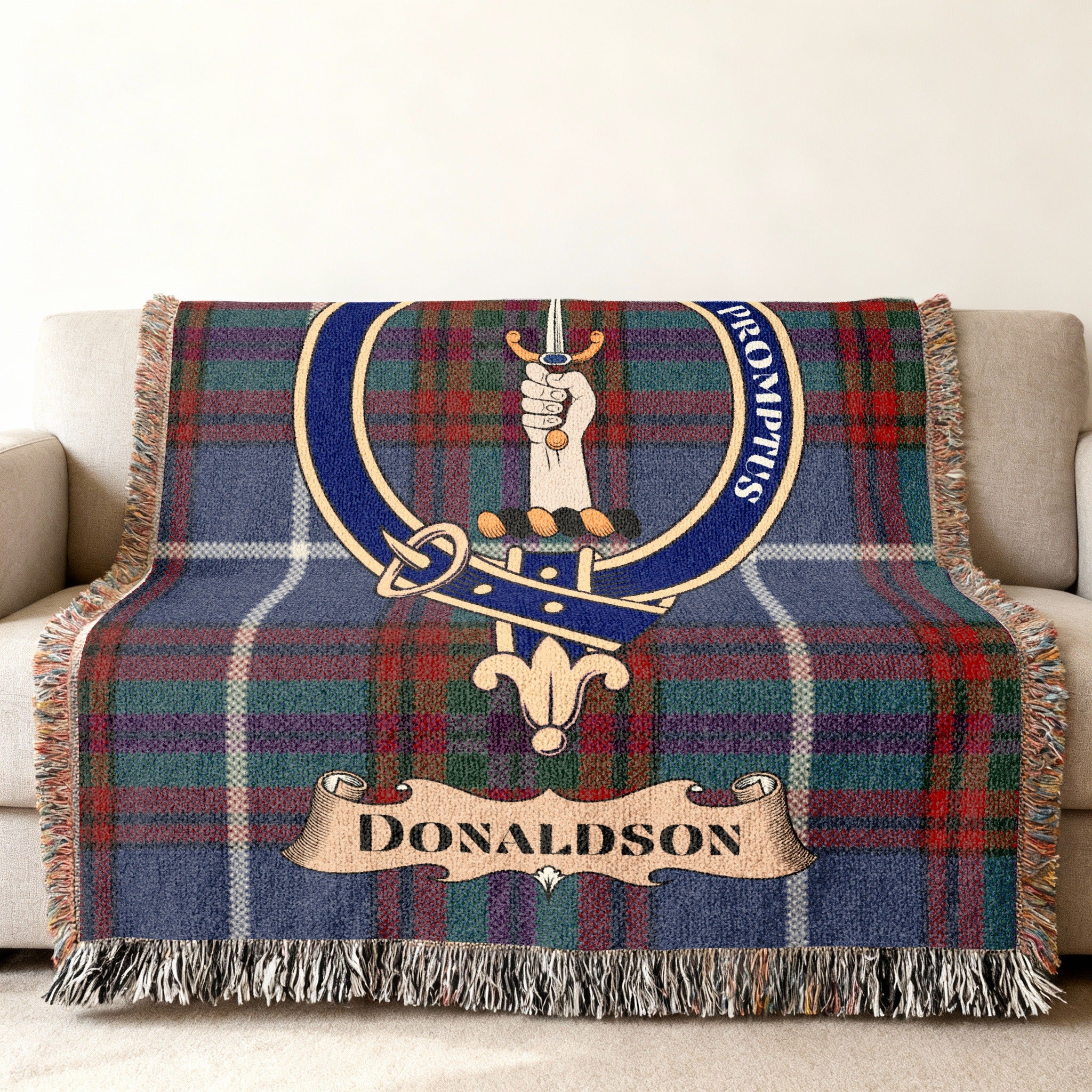 Donaldson clan tartan blanket with crest and motto draped over a sofa