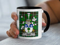White mug with black rim featuring the Kidd family crest on a tartan background.
