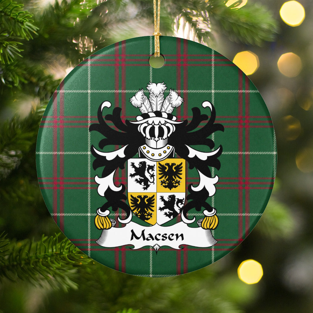 Macsen ornament hanging among Christmas tree branches and warm lights, with a quartered white-and-gold shield with black lions and eagles on Welsh National Tartan.