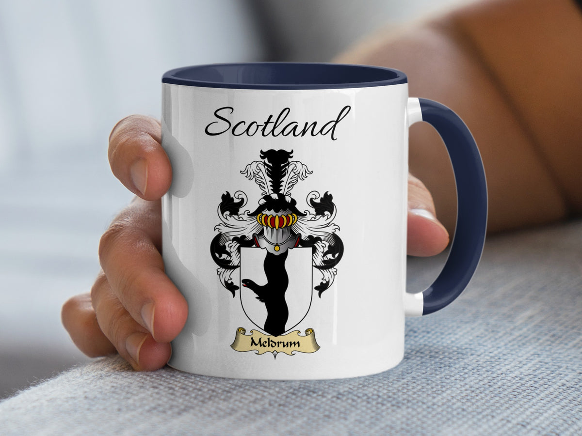 White Meldrum family emblem mug with navy handle and interior, Scotland text and double-sided artwork