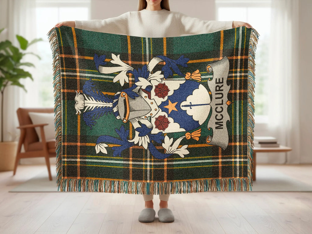 McClure tartan throw blanket with clan crest, fringed edges, held by person.