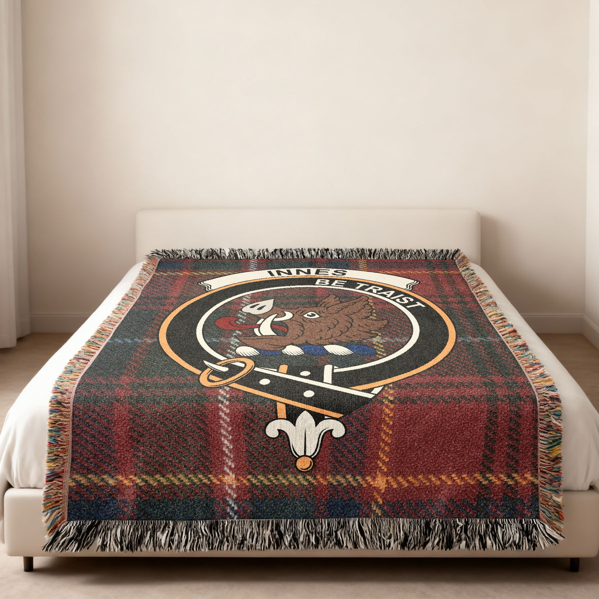 Innes Scottish woven blanket spread across a bed, showing the full crest design and tartan background