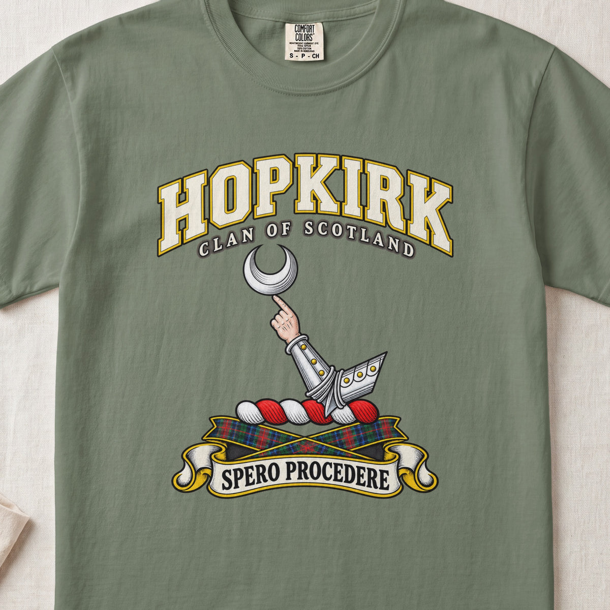 Hopkirk Scottish clan T-shirt in Moss, front view with an armoured arm holding a silver crescent and motto banner.