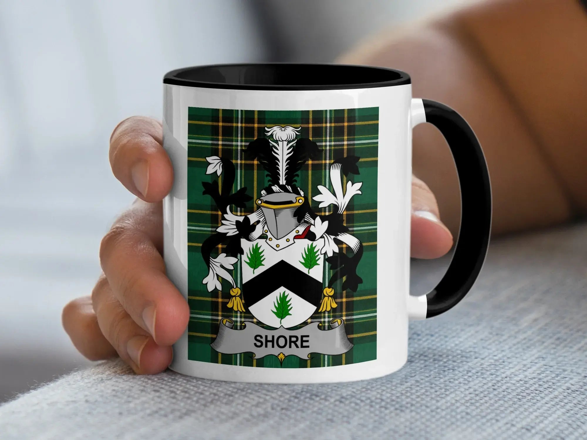 White mug with black handle featuring a green tartan shield with the name "Shore".