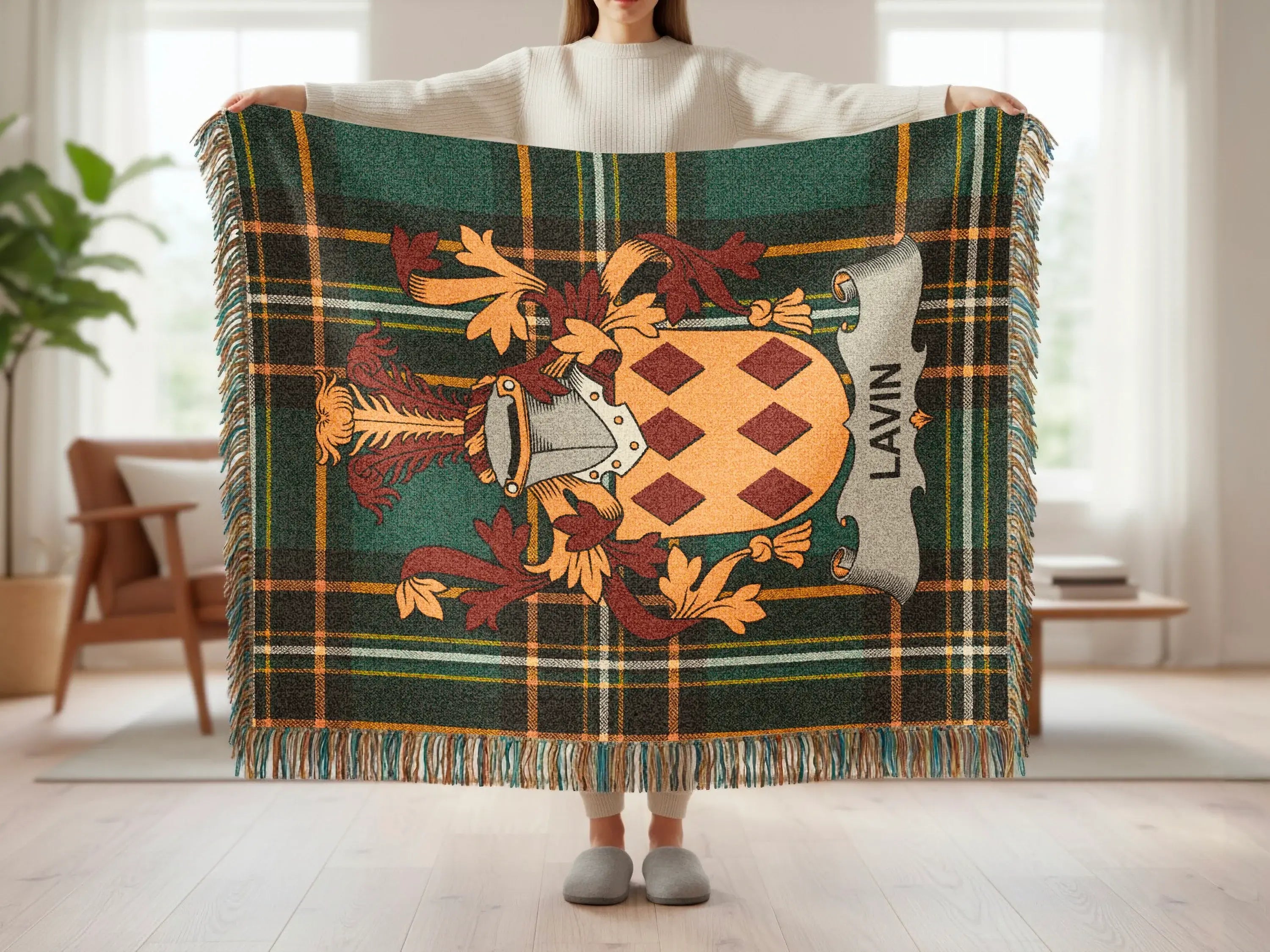 Tartan plaid throw blanket with crest and "LAVIN" text held by person.