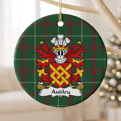 Audley ornament hanging from a pale branch; an interlaced gold fret on a red shield on Welsh national tartan.