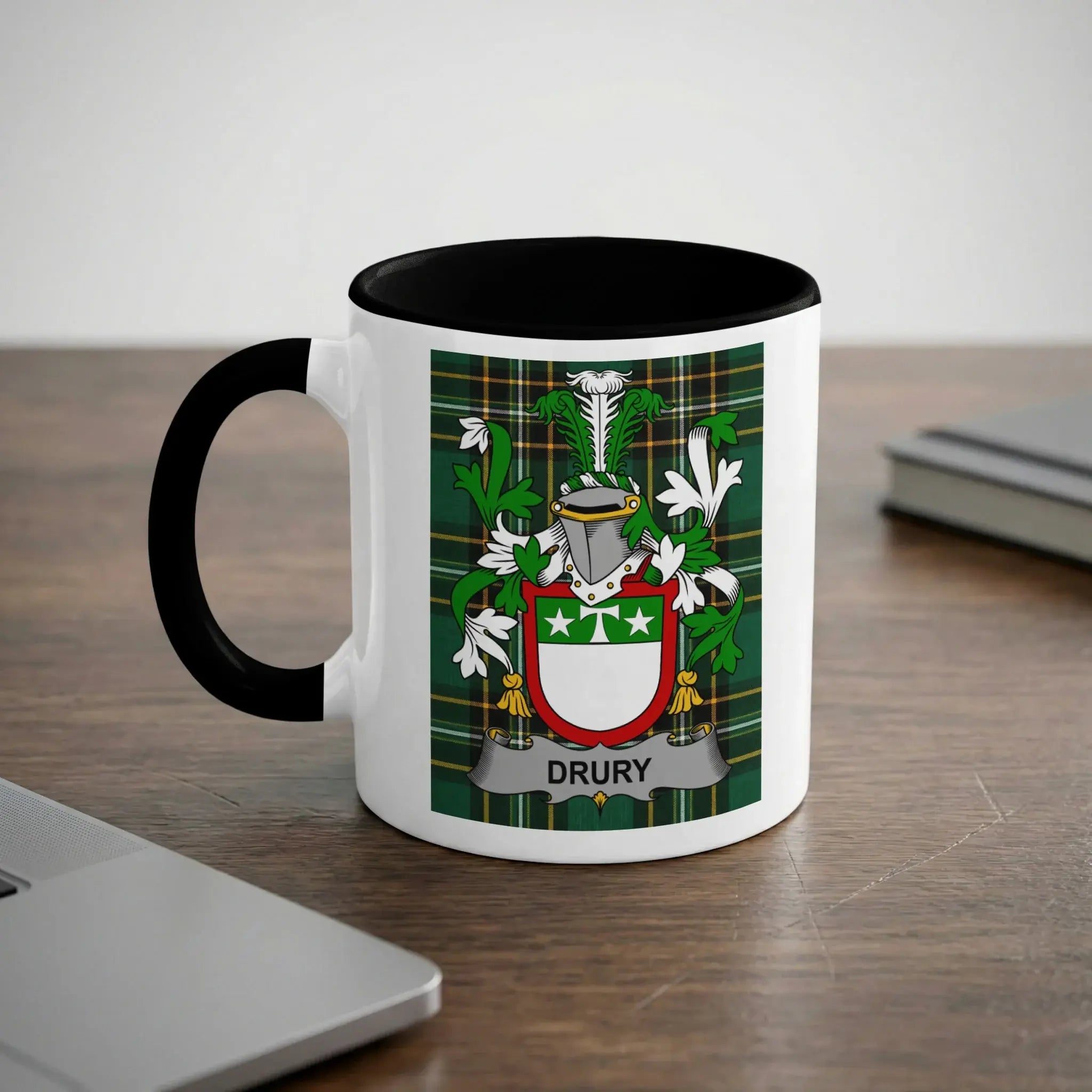 White mug with black handle, featuring the Drury family crest on a tartan background.